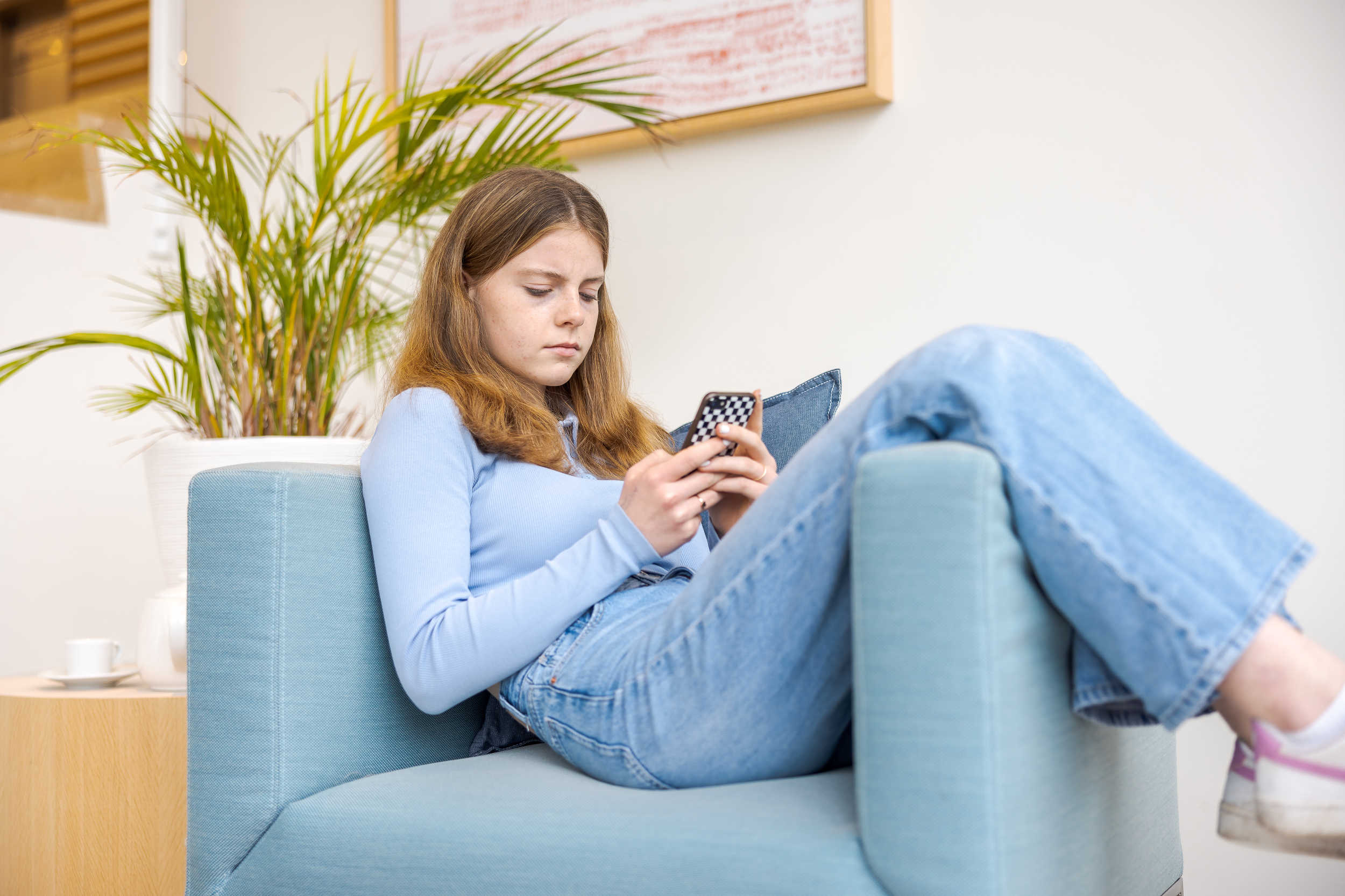 Meisje met telefoon op bank